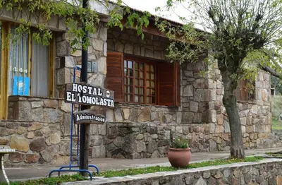 a street sign in front of a stone building at Hostal 
