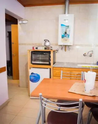 a kitchen with a table and a stove and a microwave at Hostal 