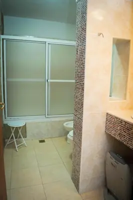 a bathroom with a toilet and a glass shower at Hostal 