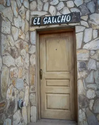 a door to a stone building with a sign above it at Hostal 