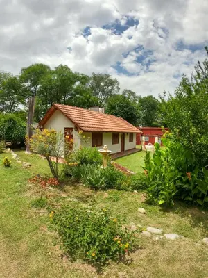 a small house in a yard with a garden at Posada Vieja Estancia in Santa Rosa de Calamuchita
