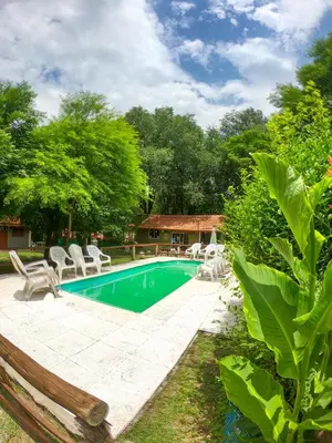 a swimming pool with chairs and a house at Posada Vieja Estancia in Santa Rosa de Calamuchita