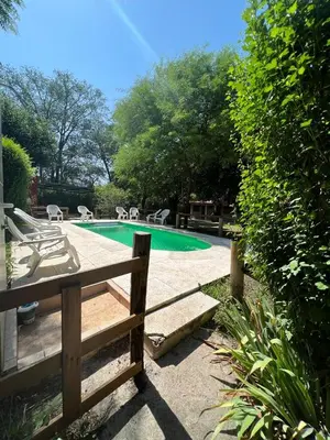 a swimming pool with chairs and a bench next to it at Posada Vieja Estancia in Santa Rosa de Calamuchita
