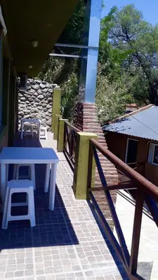 a patio with a table and a bench on a house at Apart Don Cosme in Santa Rosa de Calamuchita