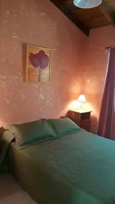 a bedroom with a bed and a painting on the wall at Apart Don Cosme in Santa Rosa de Calamuchita