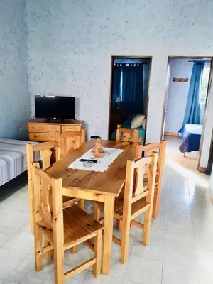 a wooden dining table and chairs in a room at Apart Don Cosme in Santa Rosa de Calamuchita
