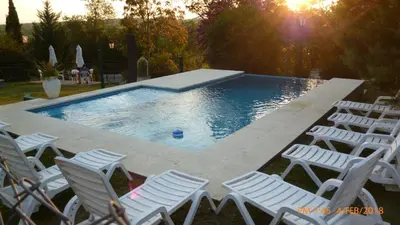 a group of chairs sitting around a swimming pool at Belvedere Hotel para Adultos in Santa Rosa de Calamuchita