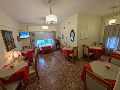 a restaurant with tables and chairs and a tv at Belvedere Hotel para Adultos in Santa Rosa de Calamuchita