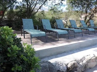 a row of blue chairs sitting on a patio at Cabañas La Comarca in Merlo