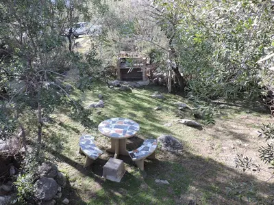 a picnic table and two benches in a yard at Cabañas La Comarca in Merlo