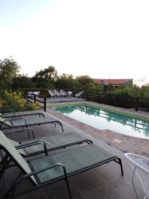 a group of chairs sitting next to a swimming pool at Cabañas La Comarca in Merlo