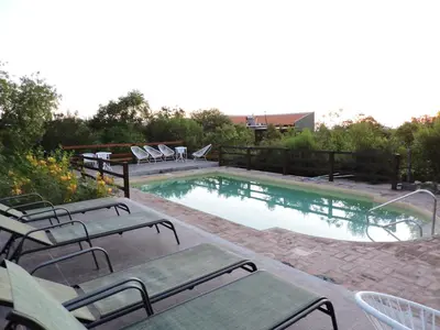 a swimming pool with lounge chairs at Cabañas La Comarca in Merlo