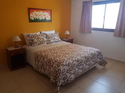a bedroom with a large bed and a window at LOS ANDES Departamentos in Villa Carlos Paz