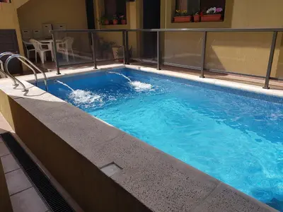 a swimming pool with blue water in a building at LOS ANDES Departamentos in Villa Carlos Paz