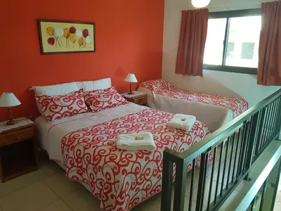a bedroom with a bed and a crib in it at LOS ANDES Departamentos in Villa Carlos Paz