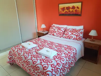 a red bedroom with a bed with two towels on it at LOS ANDES Departamentos in Villa Carlos Paz