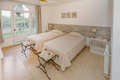 a bedroom with two beds and a window at La Posada Del Qenti in Villa Carlos Paz