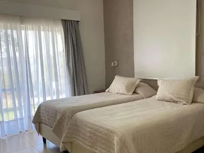 a bedroom with two beds and a large window at La Posada Del Qenti in Villa Carlos Paz