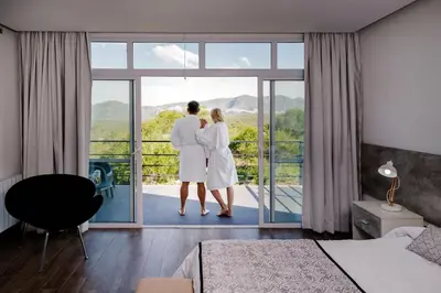 a couple looking out the window of a hotel room at La Posada Del Qenti in Villa Carlos Paz