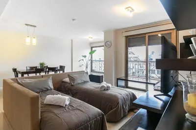 a living room with a couch and a tv and a balcony at Departamento luminoso con balcón, aire y Wi-FI-Nueva Córdoba in Cordoba