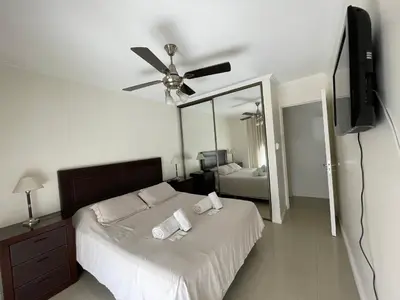 a bedroom with a bed with a ceiling fan and a mirror at Departamento luminoso con balcón, aire y Wi-FI-Nueva Córdoba in Cordoba