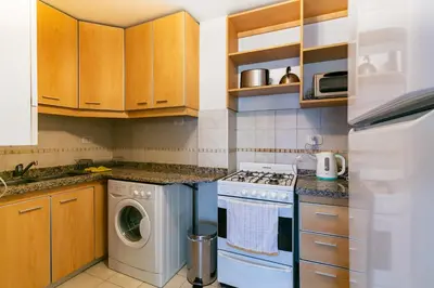 a kitchen with a washing machine and a washer at Departamento luminoso con balcón, aire y Wi-FI-Nueva Córdoba in Cordoba