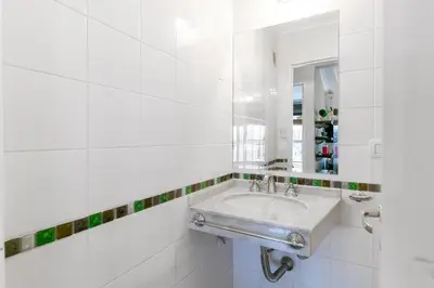 a white bathroom with a sink and a mirror at Departamento luminoso con balcón, aire y Wi-FI-Nueva Córdoba in Cordoba