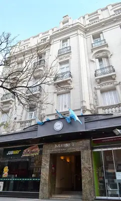 a large white building with a store front at Gran Hotel Victoria Cordoba Argentina in Cordoba