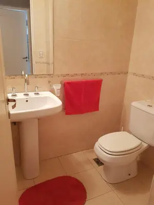 a bathroom with a toilet and a sink and a red towel at Juventus in Cordoba