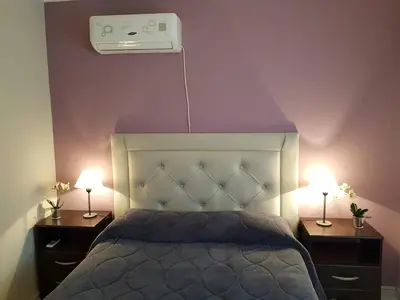 a bedroom with a bed and two night stands with lamps at Juventus in Cordoba