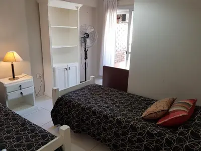 a small bedroom with two beds and a fan at Juventus in Cordoba