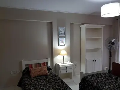 a bedroom with a bed and a lamp and a fan at Juventus in Cordoba