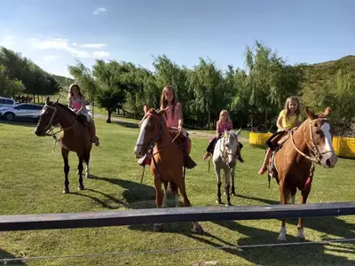 a group of girls riding horses in a field at El Zuriaco in Santa Rosa de Calamuchita