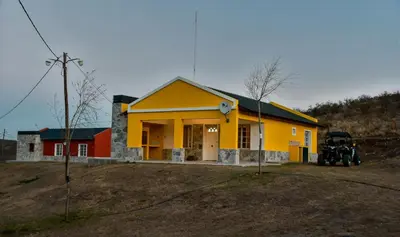 a yellow house with a motorcycle parked in front of it at El Zuriaco in Santa Rosa de Calamuchita
