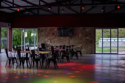 a room with tables and chairs and a stone wall at El Zuriaco in Santa Rosa de Calamuchita