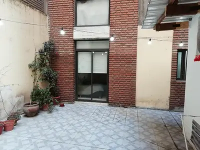 a brick building with a courtyard with potted plants at Balcarce Suits PB in Bell Ville
