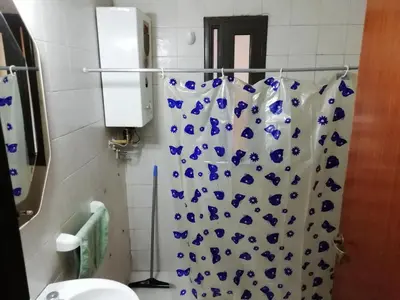 a bathroom with a blue and white shower curtain at Balcarce Suits PB in Bell Ville