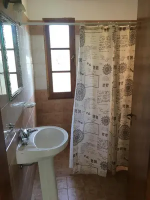 a bathroom with a sink and a shower curtain at Residencial del Golf in Alta Gracia