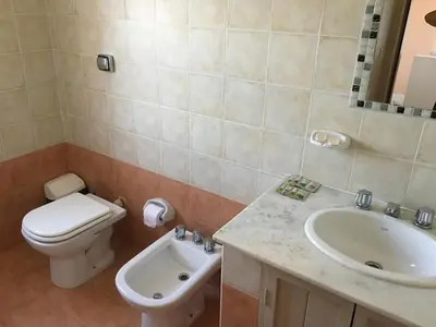 a bathroom with a toilet and a sink at Residencial del Golf in Alta Gracia