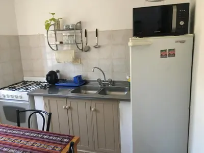 a kitchen with a refrigerator and a sink and a microwave at Residencial del Golf in Alta Gracia