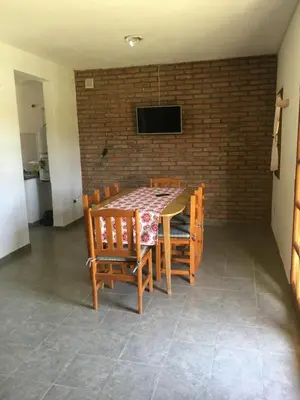a dining room with a table and chairs and a tv at Residencial del Golf in Alta Gracia