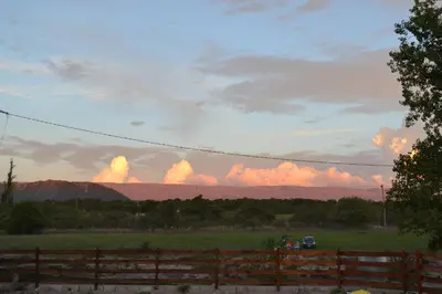 a field with a fence and clouds in the sky at Cabañas Los Álamos Panaholma in Panaholma