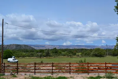 a white car parked in a field next to a fence at Cabañas Los Álamos Panaholma in Panaholma
