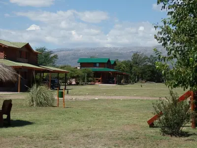 a building with a green roof in a field at Las Cortaderas Cabañas de Tronco in Nono