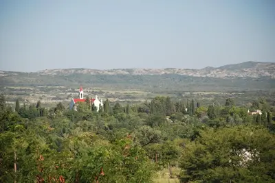 a church on top of a hill with trees at Las Cortaderas Cabañas de Tronco in Nono