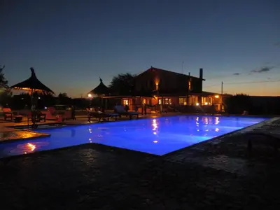 a large swimming pool with blue lighting at night at Las Cortaderas Cabañas de Tronco in Nono