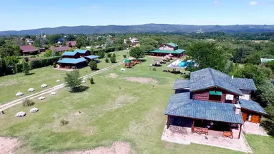 an aerial view of a house on a green field at Las Cortaderas Cabañas de Tronco in Nono