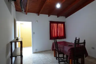a dining room with a table and a red curtain at Departamento Centrico Laprida in Cordoba