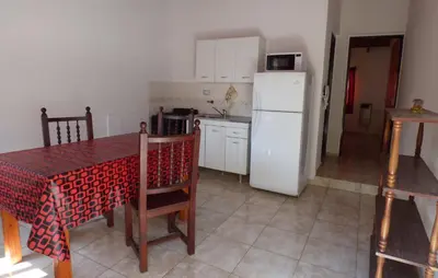 a kitchen with a table and a white refrigerator at Departamento Centrico Laprida in Cordoba