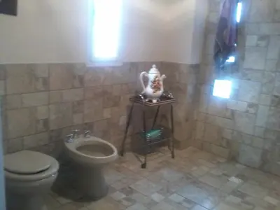 a tiled bathroom with a toilet and a sink at Aires de San Antonio in San Antonio de Arredondo